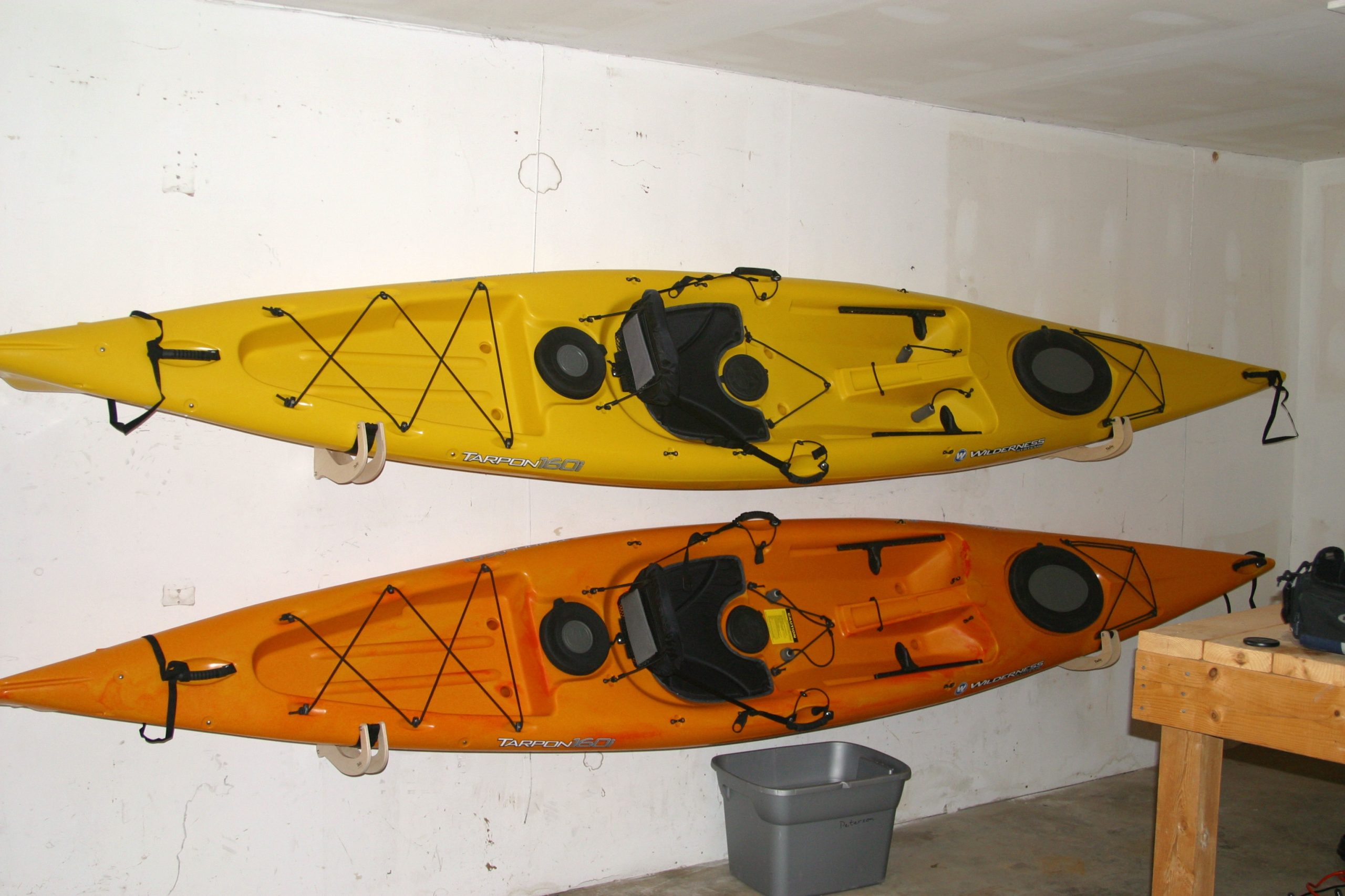 Wall-mounted hooks for hanging kayaks or canoes vertically
